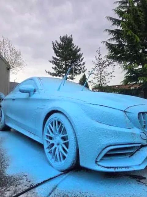 A car covered in coloured snow foam during a pre-wash
