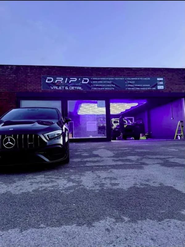 The front of the DRIP'D unit at dusk with a black Mercedes parked outside