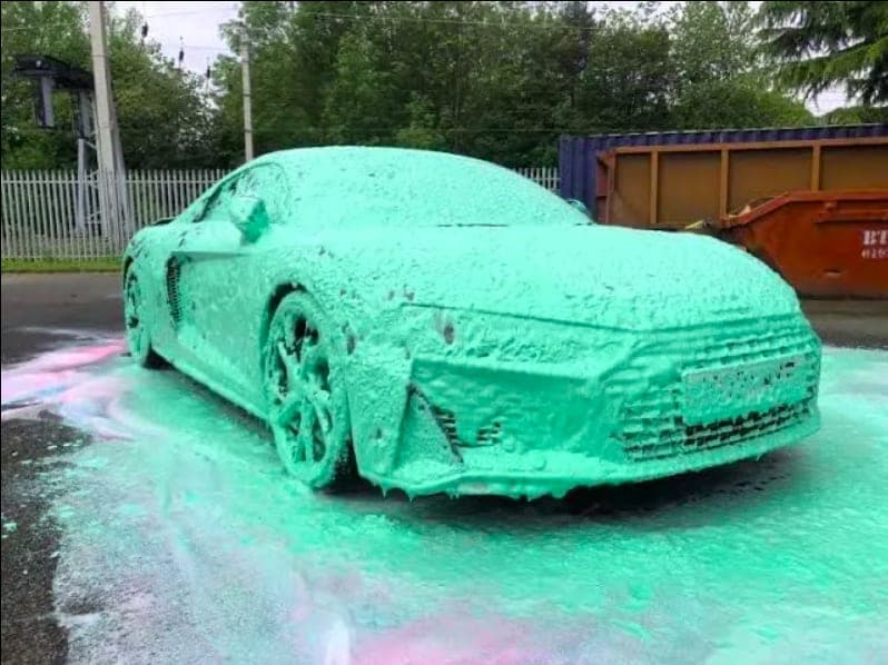 A car covered in coloured snow foam during a pre-wash