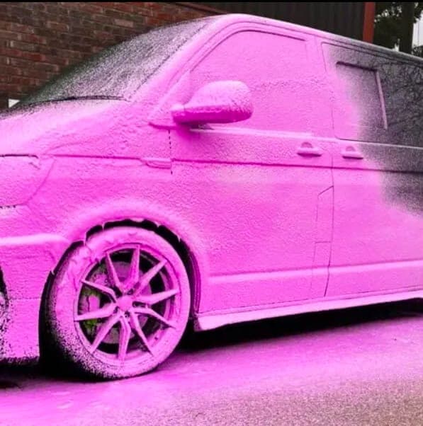 A VW Transporter covered in pink snow foam outside the DRIP'D unit